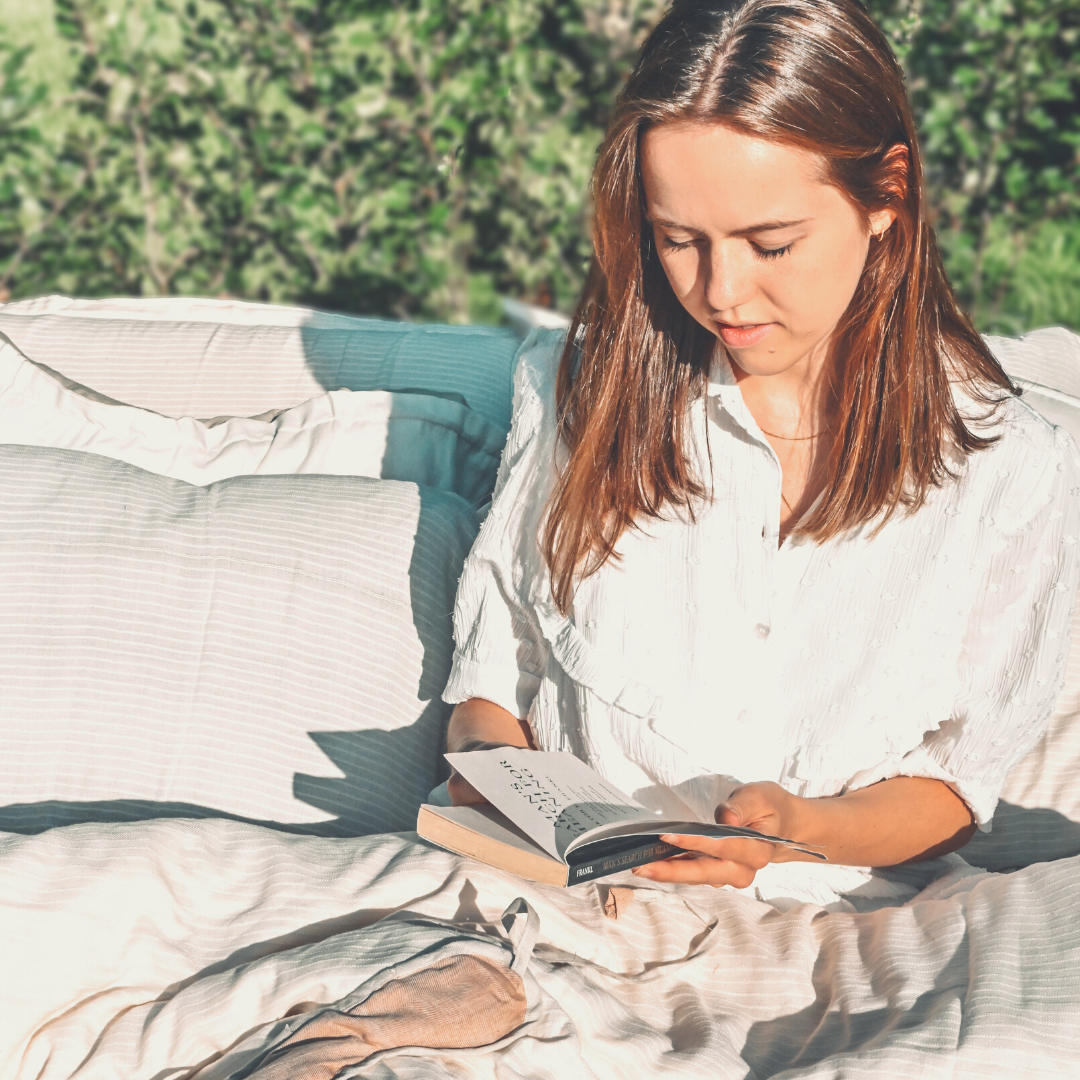woman reading book on bed